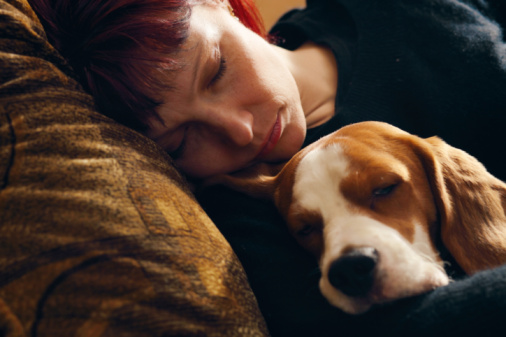 person with a migraine cuddling a dog